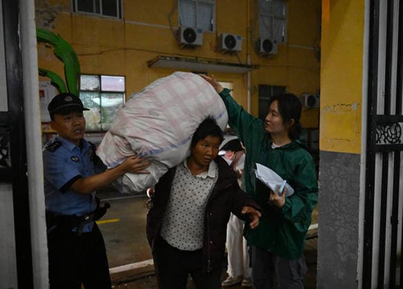 (260813) -- LUOHE, Aug. 13, 2026 -- An evacuated resident (C) arrives at a temporary shelter in Beiwudu Town of Wuyang County, Luohe, central China s Henan Province, Aug. 13, 2026. Thousands of people have been evacuated in central China s Henan Province after days of torrential rain swelled rivers and triggered a levee breach, local authorities said Thursday. In Luohe City, more than 4,500 people from 10 villages were evacuated amid rising concerns over potential river flooding. From Monday afternoon to Wednesday afternoon, the city recorded an average rainfall of 270.1 millimeters, with a peak of 434.2 millimeters, prompting authorities to activate the highest-level flood control emergency response. ) CHINA-HENAN-LUOHE-TYPHOON DOLPHI 