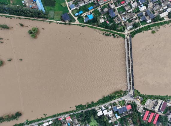 (260813) -- LUOHE, Aug. 13, 2026 -- An aerial drone photo taken on Aug. 13, 2026 shows a flood discharge scene at the Nihewa flood storage and detention area in Wuyang County of Luohe City, central China s Henan Province. Affected by Typhoon Dolphin, the 13th typhoon of the year, the Shaying River has recorded a flow rate exceeding 3,000 cubic meters per second in its Luohe section, while the water level continues to rise. In accordance with relevant contingency plans, Henan Province activated the Nihewa flood storage and detention area on Thursday. ) CHINA-HENAN-LUOHE-TYPHOON DOLPHIN-FLOOD STORAGE AREA (CN) HaoxYuan 