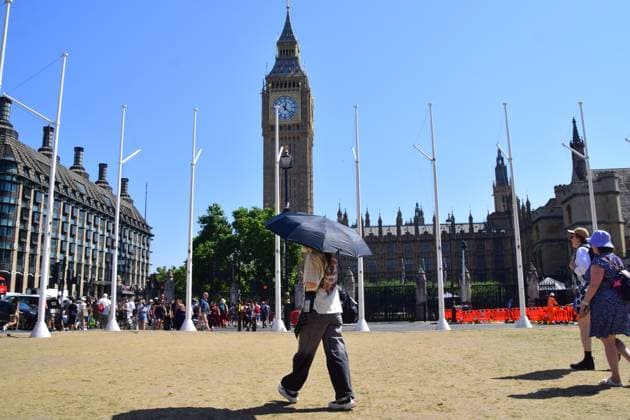 August 13, 2026, London, United Kingdom: A woman shields from the sun under an umbrella in a dry Parliament Square during the fifth heatwave of the year as drought conditions continue. London United Kingdom  - ZUMAs197 20260813_aaa_s197_075 Copyright: xVukxValcicx