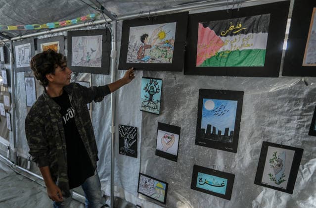 Palestinian children reflect war, displacement and hope through Art in Khan Yunis KHAN YUNIS, GAZA , PALESTINE - AUGUST 13: Works by Palestinian children are brought together in the exhibition held inside a tent at a refugee camp in the Al-Mawasi area of Khan Yunis, Gaza, Palestine on August 13, 2026. Created amid the severe humanitarian conditions resulting from the attacks that have continued since Oct. 2023, the artworks depict the children s experiences of displacement, destruction, hunger, water shortages and the loss of loved ones. Abed Rahim Khatib Anadolu Han Yunus Palestinian Territory, Occupied. Editorial use only. Please get in touch for any other usage.  Copyright: x2026xAnadoluxAbedxRahimxKhatibx