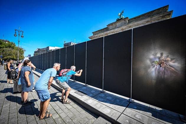 Installation zu 65 Jahre Mauerbau ** NUR FÜR REDAKTIONELLE ZWECKE ** EDITORIAL USE ONLY **<p>Am Brandenburger Tor fotografieren Touristen eine Open-Air-Installation auf dem Platz des 18. März. Die 30 Meter lange Installation, die an die einstigen Grenzanlagen erinnert, erscheint durch das Material je nach Blickwinkel durchlässig oder undurchdringlich, fotografiert am 13.08.2026 in Berlin. Berlin Berlin Berlin Copyright: MaurizioxGambarini *** Installation Marking the 65th Anniversary of the Berlin Wall’s Construction ** FOR EDITORIAL PURPOSES ONLY ** EDITORIAL USE ONLY ** p At the Brandenburg Gate, tourists photograph an open-air installation on Platz des 18 März. The 30-meter-long installation, which commemorates the former border fort Copyright: MaurizioxGambarini doc875bb2owew3er19sjmx ,EDITORIAL USE ONLY
