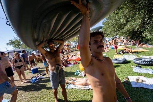 August 13, 2026, Paredes De Coura, Braga, Portugal: Festivalgoers carry an inflatable raft at the river Coura known locally as Couraiso during the daytime at Vodafone Paredes de Coura. Paredes De Coura Portugal - ZUMAs197 20260813_aab_s197_011 Copyright: xDiogoxBaptistax