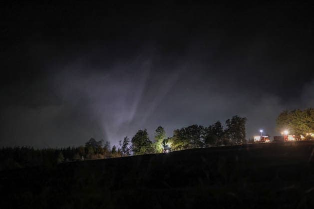 Marsberg, Nordrhein-Westfalen, Deutschland, Europa: Weitwinkelaufnahme eines nächtlichen Waldbrandeinsatzes nahe der Diemeltalsperre. Eine markante Rauchsäule steigt über dem Wald auf und wird von leistungsstarken Scheinwerfern der Feuerwehr angestrahlt. Einsatzfahrzeuge arbeiten entlang des Waldrandes, während die Löscharbeiten in der Nacht fortgesetzt werden. *** Marsberg, North Rhine-Westphalia, Germany, Europe Wide-angle shot of a nighttime forest fire operation near the Diemel Dam A striking column of smoke rises above the forest and is illuminated by the fire department’s powerful spotlights Emergency vehicles are operating along the edge of the forest as firefighting efforts continue through the night Copyright: xAymanxAlahmedx