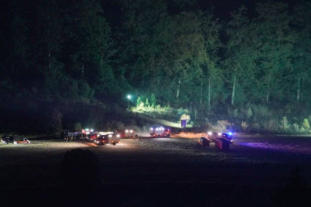 Helminghausen, Marsberg, Nordrhein-Westfalen, Deutschland, Europa: Mehrere Feuerwehrfahrzeuge und Einsatzkräfte befinden sich auf einem ausgeleuchteten Bereitstellungsplatz am Waldrand während eines nächtlichen Waldbrandeinsatzes. Mobile Lichtmasten erhellen den Bereich, während die Einsatzleitung die Löscharbeiten und die Koordination der Einsatzkräfte organisiert. *** Helminghausen, Marsberg, North Rhine-Westphalia, Germany, Europe Several fire trucks and emergency responders are stationed at a well-lit staging area at the edge of the forest during a nighttime wildfire operation. Mobile light towers illuminate the area while the incident commander organizes the firefighting efforts and coordinates the emergency responders. Copyright: xAymanxAlahmedx