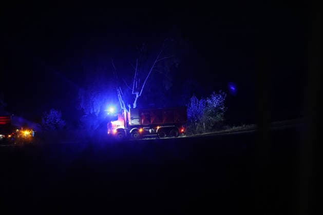 Marsberg, Nordrhein-Westfalen, Deutschland, Europa: Ein Feuerwehr-Lkw steht während eines nächtlichen Waldbrandeinsatzes nahe der Diemeltalsperre am Waldrand bereit. Blaulicht beleuchtet die Einsatzstelle, während weitere Einsatzkräfte und Fahrzeuge im Hintergrund die Brandbekämpfung fortsetzen. Die Aufnahme dokumentiert den laufenden Feuerwehreinsatz in der Nacht. *** Marsberg, North Rhine-Westphalia, Germany, Europe: A fire truck stands by at the edge of the forest during a nighttime forest fire operation near the Diemel Dam. Blue lights illuminate the scene, while additional firefighters and vehicles continue to battle the blaze in the background. The photograph documents the ongoing firefighting operation at night. Copyright: xAymanxAlahmedx