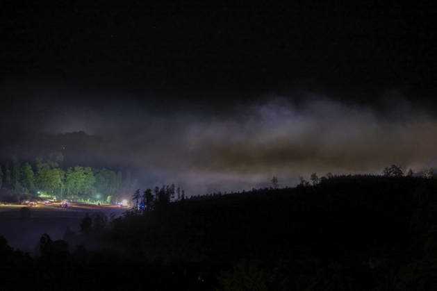 Helminghausen, Marsberg, Nordrhein-Westfalen, Deutschland, Europa: Eine ausgedehnte Rauchwolke liegt während eines nächtlichen Waldbrandeinsatzes nahe der Diemeltalsperre über dem Waldgebiet. Feuerwehrfahrzeuge und Einsatzkräfte arbeiten entlang des Waldrandes, während Scheinwerfer und Blaulicht die großflächige Einsatzstelle beleuchten. *** Helminghausen, Marsberg, North Rhine-Westphalia, Germany, Europe A vast cloud of smoke hangs over the forest area during a nighttime wildfire operation near the Diemel Dam. Fire trucks and emergency responders are working along the edge of the forest, while floodlights and blue lights illuminate the extensive scene of the operation. Copyright: xAymanxAlahmedx