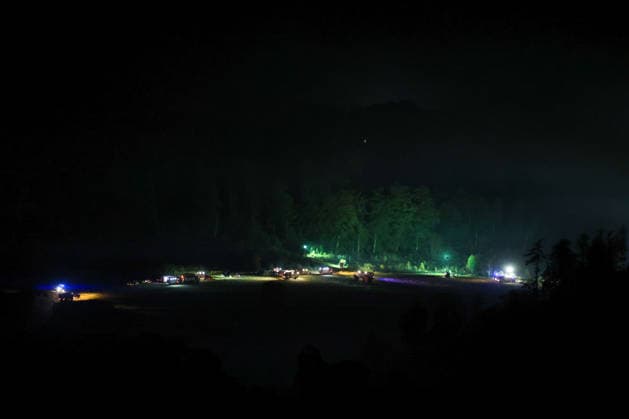 Helminghausen, Marsberg, Nordrhein-Westfalen, Deutschland, Europa: Weitwinkelaufnahme eines nächtlichen Waldbrandeinsatzes nahe der Diemeltalsperre. Zahlreiche Feuerwehrfahrzeuge und Einsatzkräfte sind entlang des Waldrandes und auf freiem Gelände verteilt, während leistungsstarke Scheinwerfer und Blaulicht die Einsatzstelle ausleuchten und Rauch über dem betroffenen Gebiet sichtbar ist. *** Helminghausen, Marsberg, North Rhine-Westphalia, Germany, Europe Wide-angle shot of a nighttime forest fire operation near the Diemel Dam. Numerous fire trucks and emergency personnel are stationed along the edge of the forest and in open areas, while powerful spotlights and blue lights illuminate the scene, and smoke is visible above the affec Copyright: xAymanxAlahmedx