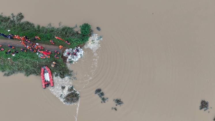 (260814) -- BEIJING, Aug. 14, 2026 -- An aerial drone photo shows repair work underway at the site of a levee breach along the Beiru River in Jiaxian County, central China s Henan Province, Aug. 13, 2026. Thousands of people have been evacuated in Henan Province after days of torrential rain swelled rivers and triggered a levee breach, local authorities said Thursday. In Pingdingshan City, more than 2,000 people were relocated to safety after a levee along the Beiru River in Jiaxian County gave way on Wednesday night, following extreme rainfall and large-volume discharges from upstream reservoirs. No casualties have been reported so far. ) XINHUA PHOTOS OF THE DAY YangxJinxin 