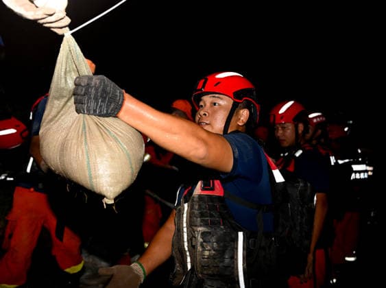 (260814) -- JIAXIAN, Aug. 14, 2026 -- Rescuers work at the site of a levee breach along the Beiru River in Jiaxian County, central China s Henan Province, Aug. 13, 2026. A levee along the Beiru River in Jiaxian County gave way on Wednesday night, following extreme rainfall and large-volume discharges from upstream reservoirs. As of Thursday, a total of 2,182 people had been evacuated to safety, with no casualties reported so far. Efforts to contain the levee breach are underway. ) CHINA-HENAN-JIAXIAN COUNTY-LEVEE BREACH-REPAIR WORK (CN) HaoxYuan 