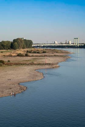 Poller Wiesen und Rodenkirchener Brücke - Durch die historisch niedrigen Pegelstände im Rhein ist die Logistik extremst gestört. Hierdurch entstehen Herausforderungen und Folgen für den Alltag. Es droht das Abschneiden der Transportwege im Rhein. Die Kosten für den Verbraucher steigen im Bereich der Lebensmitteln, bei den Kraftstoffen und anderen Bereichen durch gestiegene Transportkosten. Unternehmen sind gezwungen, die Produktionen zu drosseln. Köln, 13.08.2026 *** Poller Wiesen and Rodenkirchen Bridge: Due to historically low water levels in the Rhine, logistics have been severely disrupted. This is creating challenges and consequences for everyday life. There is a risk that transport routes along the Rhine will be cut off. Costs f Foto:xR.xSchmiegeltx xFuturexImagex neidrigwasser_6812