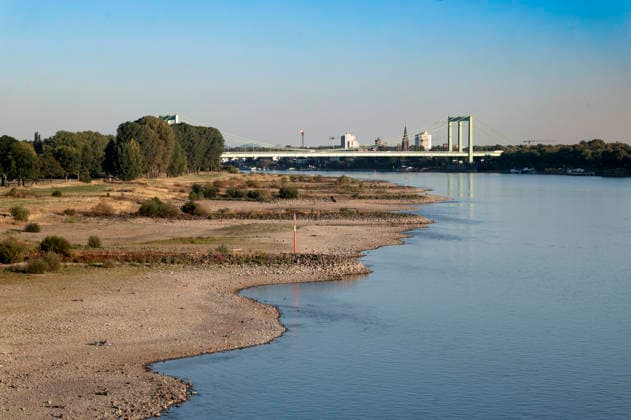 Poller Wiesen und Rodenkirchener Brücke - Durch die historisch niedrigen Pegelstände im Rhein ist die Logistik extremst gestört. Hierdurch entstehen Herausforderungen und Folgen für den Alltag. Es droht das Abschneiden der Transportwege im Rhein. Die Kosten für den Verbraucher steigen im Bereich der Lebensmitteln, bei den Kraftstoffen und anderen Bereichen durch gestiegene Transportkosten. Unternehmen sind gezwungen, die Produktionen zu drosseln. Köln, 13.08.2026 *** Poller Wiesen and Rodenkirchen Bridge: Due to historically low water levels in the Rhine, logistics have been severely disrupted. This is creating challenges and consequences for everyday life. There is a risk that transport routes along the Rhine will be cut off. Costs f Foto:xR.xSchmiegeltx xFuturexImagex neidrigwasser_6813