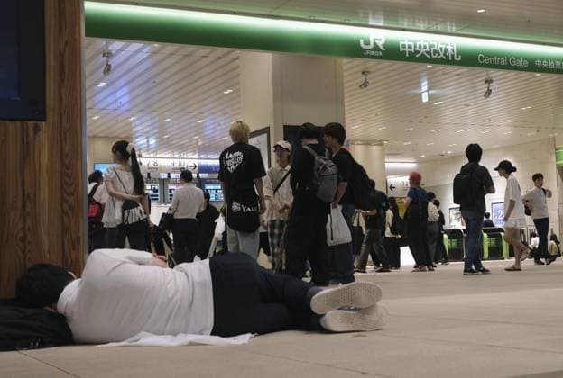 Aftermath of torrential rain in eastern Japan A man lies on the floor near an entrance to JR Chiba Station in Chiba, east of Tokyo, in the early morning of Aug. 14, 2026, as train services remain suspended following torrential rain overnight. Japan s weather agency issued its highest Level 5 warning for downpours in parts of Chiba Prefecture.  A14AA0005625738P