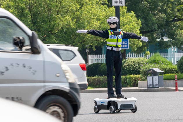 YONGKANG, CHINA - AUGUST 14: A robot traffic police officer assists in directing traffic at an intersection on August 14, 2026 in Yongkang, Jinhua, Zhejiang Province of China. Local authorities have launched a trial operation of robot traffic police to assist with road safety management.  Copyright: xVCGx 111659918424