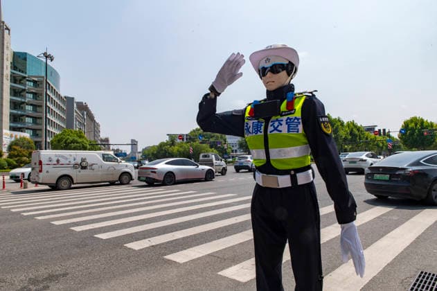 YONGKANG, CHINA - AUGUST 14: A robot traffic police officer advises riders to wear safety helmets at an intersection on August 14, 2026 in Yongkang, Jinhua, Zhejiang Province of China. Local authorities have launched a trial operation of robot traffic police to assist with road safety management.  Copyright: xVCGx 111659918403