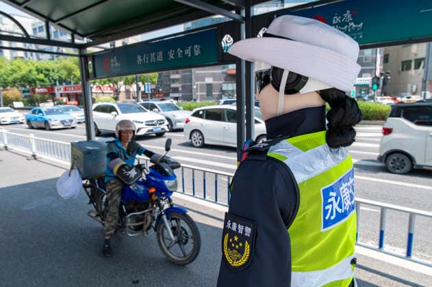 YONGKANG, CHINA - AUGUST 14: A robot traffic police officer advises riders to wear safety helmets at an intersection on August 14, 2026 in Yongkang, Jinhua, Zhejiang Province of China. Local authorities have launched a trial operation of robot traffic police to assist with road safety management.  Copyright: xVCGx 111659918407