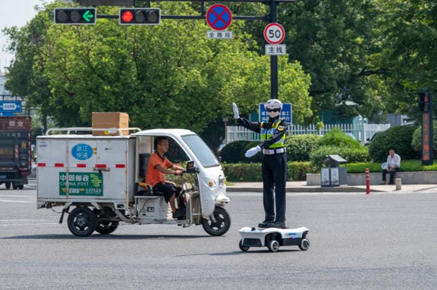 YONGKANG, CHINA - AUGUST 14: A robot traffic police officer assists in directing traffic at an intersection on August 14, 2026 in Yongkang, Jinhua, Zhejiang Province of China. Local authorities have launched a trial operation of robot traffic police to assist with road safety management.  Copyright: xVCGx 111659918425