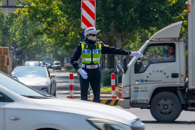 YONGKANG, CHINA - AUGUST 14: A robot traffic police officer assists in directing traffic at an intersection on August 14, 2026 in Yongkang, Jinhua, Zhejiang Province of China. Local authorities have launched a trial operation of robot traffic police to assist with road safety management.  Copyright: xVCGx 111659918426