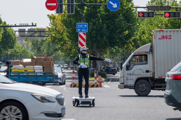 YONGKANG, CHINA - AUGUST 14: A robot traffic police officer assists in directing traffic at an intersection on August 14, 2026 in Yongkang, Jinhua, Zhejiang Province of China. Local authorities have launched a trial operation of robot traffic police to assist with road safety management.  Copyright: xVCGx 111659918427