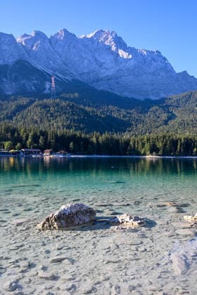 Wetterfeature, Morgenstille am Eibsee: Unterhalb der Zugspitze liegt der See bei Grainau nahe Garmisch-Partenkirchen in den frühen Stunden noch ruhig und nahezu unberührt. Doch an heißen Sommertagen ändert sich das Bild häufig schon ab Mittag. Dann strömen zahlreiche Ausflügler und Urlauber an den durch soziale Medien weltweit bekannt gewordenen Bergsee. Der zunehmende Massentourismus sorgt regelmäßig für einen regelrechten Besucheransturm. Unter dem hohen Verkehrsaufkommen, zugeparkten Straßen und dem großen Andrang leiden zunehmend auch die Anwohner in Grainau und rund um den Eibsee. Grainau Bayern Deutschland Grainau *** Weather Feature, Morning Stillness at Eibsee. Nestled below the Zugspitze near Grainau, close to Garmisch- Copyright: x xonw-imagesx xMariusxBullingx