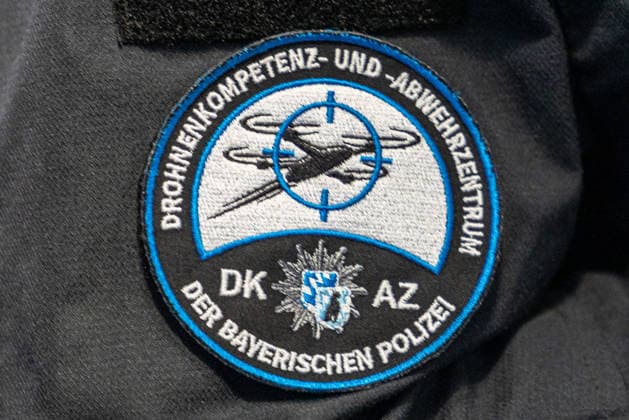 Drohnendetektion und -abwehr der Bayerischen Polizei, Flughafen Nürnberg, 14.08.2026 Ärmelabzeichen des Drohnenkompetenz- und -abwehrzentrums der Bayerischen Polizei zeigt eine stilisierte Drohne im Fadenkreuz. Die Polizei informierte über Möglichkeiten zur Drohnendetektion und -abwehr sowie den geplanten Ausbau technischer und personeller Ressourcen der Grenzpolizeiinspektion. Nürnberg Flughafen Bayern Deutschland *** Drone Detection and Defense by the Bavarian Police, Nuremberg Airport, August 14, 2026: The sleeve insignia of the Bavarian Police’s Drone Competence and Defense Center features a stylized drone in a crosshair. The police provided information on drone detection and defense capabilities, as well as the planned expansion o 20260814-1V9A7164-M4000