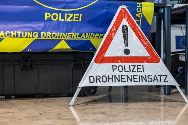 Drohnendetektion und -abwehr der Bayerischen Polizei, Flughafen Nürnberg, 14.08.2026 Ein Warnschild mit der Aufschrift Polizei Drohneneinsatz steht vor einem Banner der Polizei zum Thema Drohnenlandeplatz. Die Bayerische Polizei informiert über ihre Möglichkeiten zur Drohnendetektion und -abwehr sowie den geplanten Ausbau technischer Ausstattung und personeller Ressourcen der Grenzpolizeiinspektion. Nürnberg Flughafen Bayern Deutschland *** Drone Detection and Defense by the Bavarian Police, Nuremberg Airport, August 14, 2026 A warning sign reading Police Drone Operations stands in front of a police banner regarding drone landing sites. The Bavarian Police provides information about its capabilities for drone detection and defense, 20260814-286A5332-M4000