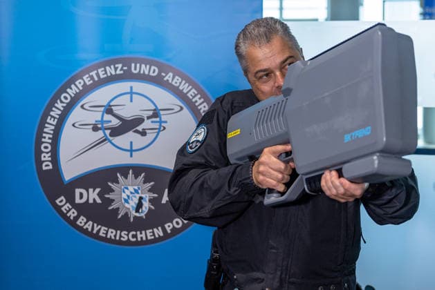 Drohnendetektion und -abwehr der Bayerischen Polizei, Flughafen Nürnberg, 14.08.2026 Ein Polizeibeamter der Bayerischen Polizei demonstriert ein Gerät zur Drohnendetektion und -abwehr der Marke Skyfend. Im Hintergrund ist das Logo der Drohnenkompetenz- und -abwehrzentrale der Bayerischen Polizei zu sehen. Die Vorführung fand im Rahmen einer Informationsveranstaltung am Flughafen Nürnberg statt. Nürnberg Flughafen Bayern Deutschland *** Drone Detection and Defense by the Bavarian Police, Nuremberg Airport, August 14, 2026 A Bavarian police officer demonstrates a Skyfend drone detection and defense device. The logo of the Bavarian Police’s Drone Competence and Defense Center is visible in the background. The demonstration took place as p 20260814-286A5424-M4000