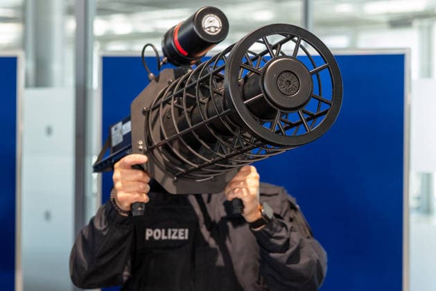 Drohnendetektion und -abwehr der Bayerischen Polizei, Flughafen Nürnberg, 14.08.2026 Ein Polizeibeamter demonstriert das tragbare, schultergestützte Störsender-System Counter UAV Jammer HP 47+ PRO V7 zur Drohnendetektion und -abwehr. Das Gerät wird wie ein Rohrsystem auf der Schulter gehalten und zielgerichtet ausgerichtet. Nürnberg Flughafen Bayern Deutschland *** Drone Detection and Defense by the Bavarian Police, Nuremberg Airport, August 14, 2026 A police officer demonstrates the portable, shoulder-mounted jamming system, the Counter UAV Jammer HP 47 PRO V7, for drone detection and defense. The device is held on the shoulder like a tube and aimed at the target. Nuremberg Airport, Bavaria, Germany 20260814-286A5438-M4000