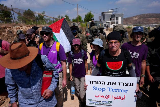 Activists attempt to deliver supplies to Palestinian families near Nablus NABLUS, WEST BANK, PALESTINE - AUGUST 14: Palestinian, Israeli and foreign activists attempt to deliver basic supplies to three Palestinian families living in the Ras al-Ayn area of Qusra, south of Nablus in the West Bank, Palestine, on August 14, 2026, as Israelis have blocked roads leading to the families’ homes since August 9, restricting access to and from the area in the presence of Israeli soldiers, with the restrictions remaining in place. Issam Rimawi Anadolu Nablus West Bank. Editorial use only. Please get in touch for any other usage.  Copyright: x2026xAnadoluxIssamxRimawix