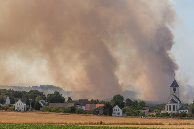 Der Brand im Hürtgenwald ( Kreis Düren NRW ) breitet sich hinter der Ortschaft Birgel mit der Pfarrkirche Sankt Martinus aus. Brand im Hürtgenwald *** The fire in the Hürtgenwald, Düren County, North Rhine-Westphalia, is spreading behind the village of Birgel, where the St. Martinus parish church is located. Fire in the Hürtgenwald