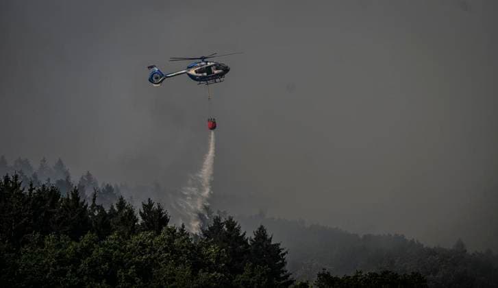Waldbrände im Kreis Düren in der Eifel Hürtgenwald ** NUR FÜR REDAKTIONELLE ZWECKE ** EDITORIAL USE ONLY **<p>Hubschrauber im Dauereinsatz, beladen ihre Wassertanks in Großhau auf einem Feld , im Hintergrund Rauch vom Waldbrand , am Freitag, dem 14 08 2026 Waldbrände im Kreis Düren in der Eifel Hürtgenwald Deutschland NRW Essen Copyright: KerstinxKokoska *** Forest fires in the Düren district in the Eifel region, Hürtgenwald ** FOR EDITORIAL PURPOSES ONLY ** EDITORIAL USE ONLY ** Helicopters in continuous operation are filling their water tanks in a field in Großhau, with smoke from the forest fire visible in the background, on Friday, August 14, 2026. Forest fires in the Düren district in the Eifel region, Hürtgenwald, Ger Copyright: KerstinxKokoska doc875pqudjthigdv40ov2 ,EDITORIAL USE ONLY