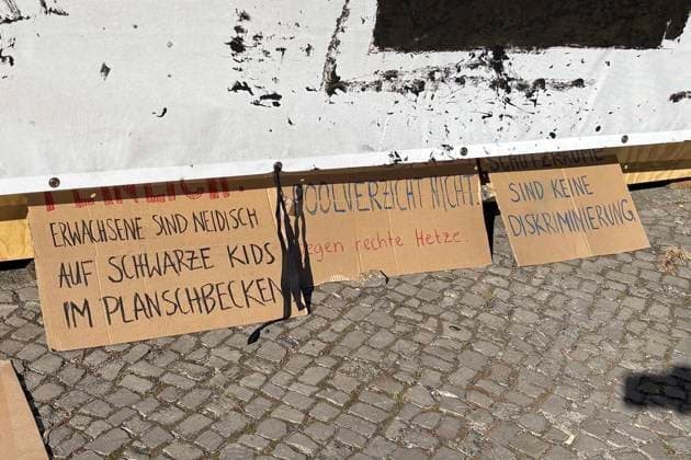 14.08.2026, Volksbühne Berlin hat ein temporäres kostenloses Schwimmbad auf dem Rosa-Luxemburg-Platz aufgestellt, Volksbad, mit Transparent Fickt Euch ! Fuck You! nachdem es Proteste gegen eine geschlossene Veranstaltung für schwarze Menschen gegebn hat, Berlin Deutschland, Germany *** August 14, 2026: The Volksbühne Berlin set up a temporary, free swimming pool on Rosa Luxemburg Platz—the Volksbad —featuring a banner reading Fickt Euch, Fuck You following protests against a private event for Black people, Berlin, Germany