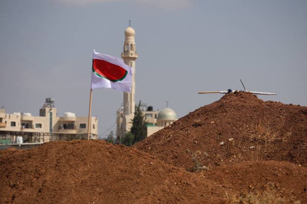 Activists Remove Flags From Beit Sahour A red-and-white flag flies from a mound of earth with a mosque visible in the background in Beit Sahour, east of Bethlehem in the occupied West Bank, on August 14, 2026. The activists said settlers had placed the symbols on the house after October 7, 2023, in what they described as an attempt to seize control of the property, and that settlers opened fire toward them as the items were removed, with no injuries reported. Bethlehem West Bank Palestinian Territories Copyright: xMosabxShawerx