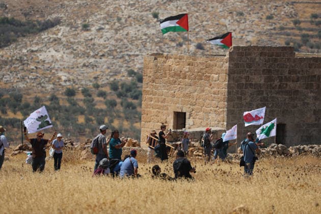 Activists Remove Flags From Beit Sahour Activists carrying flags stand near a Palestinian home with Palestinian flags on its roof in Beit Sahour, east of Bethlehem in the occupied West Bank, on August 14, 2026. The activists said settlers had placed the symbols on the house after October 7, 2023, in what they described as an attempt to seize control of the property, and that settlers opened fire toward them as the items were removed, with no injuries reported. Bethlehem West Bank Palestinian Territories Copyright: xMosabxShawerx