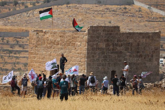 Activists Remove Flags From Beit Sahour Activists gather around a Palestinian home as Palestinian flags fly from its roof in Beit Sahour, east of Bethlehem in the occupied West Bank, on August 14, 2026. The activists said settlers had placed the symbols on the house after October 7, 2023, in what they described as an attempt to seize control of the property, and that settlers opened fire toward them as the items were removed, with no injuries reported. Bethlehem West Bank Palestinian Territories Copyright: xMosabxShawerx