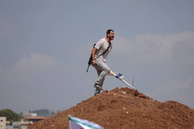 Activists Remove Flags From Beit Sahour An armed man runs across a mound of earth while carrying a bottle in Beit Sahour, east of Bethlehem in the occupied West Bank, on August 14, 2026. The activists said settlers had placed the symbols on the house after October 7, 2023, in what they described as an attempt to seize control of the property, and that settlers opened fire toward them as the items were removed, with no injuries reported. Bethlehem West Bank Palestinian Territories Copyright: xMosabxShawerx