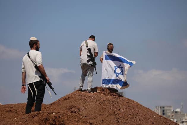 Activists Remove Flags From Beit Sahour Armed men stand around an Israeli flag on a mound of earth in Beit Sahour, east of Bethlehem in the occupied West Bank, on August 14, 2026. The activists said settlers had placed the symbols on the house after October 7, 2023, in what they described as an attempt to seize control of the property, and that settlers opened fire toward them as the items were removed, with no injuries reported. Bethlehem West Bank Palestinian Territories Copyright: xMosabxShawerx