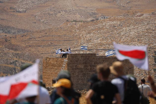 Activists Remove Flags From Beit Sahour Activists carrying watermelon-themed flags face a Palestinian home displaying Israeli flags in Beit Sahour, east of Bethlehem in the occupied West Bank, on August 14, 2026. The activists said settlers had placed the symbols on the house after October 7, 2023, in what they described as an attempt to seize control of the property, and that settlers opened fire toward them as the items were removed, with no injuries reported. Bethlehem West Bank Palestinian Territories Copyright: xMosabxShawerx