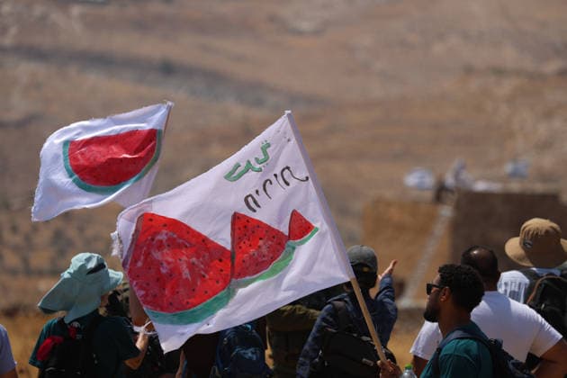 Activists Remove Flags From Beit Sahour Activists wave flags bearing watermelon motifs during the action in Beit Sahour, east of Bethlehem in the occupied West Bank, on August 14, 2026. The activists said settlers had placed the symbols on the house after October 7, 2023, in what they described as an attempt to seize control of the property, and that settlers opened fire toward them as the items were removed, with no injuries reported. Bethlehem West Bank Palestinian Territories Copyright: xMosabxShawerx