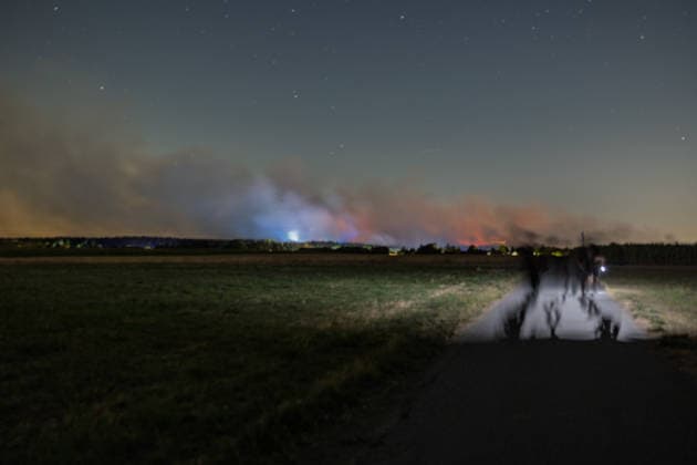 Nächtliche Löscharbeiten am Waldbrand im Hürtgenwald bei Kleinhau Nachtaufnahme aus Kleinhau (Gemeinde Hürtgenwald, Kreis Düren): Die Löscharbeiten am Großbrand im Hürtgenwald laufen auch in der Nacht auf Hochtouren rund 500 Einsatzkräfte lösen sich im 12-Stunden-Rhythmus ab. Eine Mischung aus Flammenschein, Scheinwerferlicht und Blaulicht taucht den aufsteigenden Brandrauch in ein dramatisches Licht. Hürtgenwald Kleinhau Nordrhein-Westfalen Deutschland *** Nighttime firefighting efforts at the forest fire in the Hürtgenwald near Kleinhau; nighttime photo taken from Kleinhau, municipality of Hürtgenwald, Düren District: Firefighting efforts at the major wildfire in the Hürtgenwald are continuing at full speed through the nigh Copyright: xMarcxJohnx