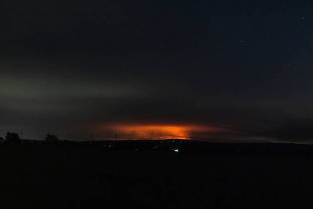 Nachtaufnahme: Waldbrand im Hohen Venn hinter Windkrafträdern bei Kleinhau Nachtaufnahme aus Kleinhau (Gemeinde Hürtgenwald): Am Horizont, rund 26 Kilometer entfernt in Belgien, erhellt rötlicher Flammenschein den Brandrauch des Großbrands im Hohen Venn bei Drossart (Gemeinde Baelen) dort ist die Fläche seit dem Nachmittag von rund 1 auf etwa 80 Hektar gewachsen, ein Notfallplan der Provinz Lüttich wurde ausgerufen. Im Vordergrund sind Windkrafträder zu erkennen. Hürtgenwald Kleinhau Nordrhein-Westfalen Deutschland *** Night shot of a forest fire in the High Fens behind wind turbines near Kleinhau. Night shot taken from Kleinhau, in the municipality of Hürtgenwald. On the horizon, about 26 kilometers away in Belgium, a reddish g Copyright: xMarcxJohnx