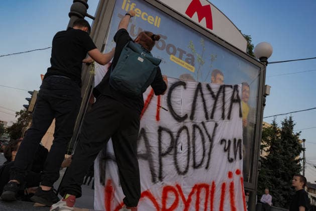 Kharkiv Protesters Demand Reinstatement of Defence Minister Fedorov - Ukraine Demonstrators hang a hand-painted banner reading Sluha Narodu (Servant of the People) and Koruptii (Corruption) in red and black on a billboard near a metro station entrance at Freedom Square in Kharkiv, Ukraine, on August 14, 2026. The action was part of a rally demanding the reinstatement of Minister of Defence Mykhailo Fedorov, held on the 29th day of continuous nationwide protests against his dismissal by President Zelensky. Photo by Yevhen Titov ABACAPRESS.COM Kharkiv Kharkiv Oblast Ukraine  Copyright: xTitovxYevhen ABACAx