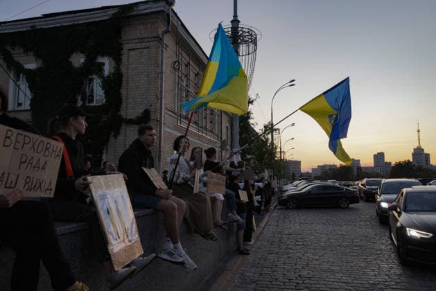 Kharkiv Protesters Demand Reinstatement of Defence Minister Fedorov - Ukraine Demonstrators sit along a low wall at Freedom Square (????? ???????), holding Ukrainian flags and cardboard placards — one reading ???????? ???? — ??? ????? ( Verkhovna Rada is our way out ) — during a rally demanding the reinstatement of Mykhailo Fedorov as Minister of Defence, in Kharkiv, Ukraine, on August 14, 2026. The protest, part of nationwide demonstrations running since July 24, drew approximately 500 Kharkiv residents that evening, the largest turnout over the preceding three days, organizers said. Photo by Yevhen Titov ABACAPRESS.COM Kharkiv Kharkiv Oblast Ukraine  Copyright: xTitovxYevhen ABACAx