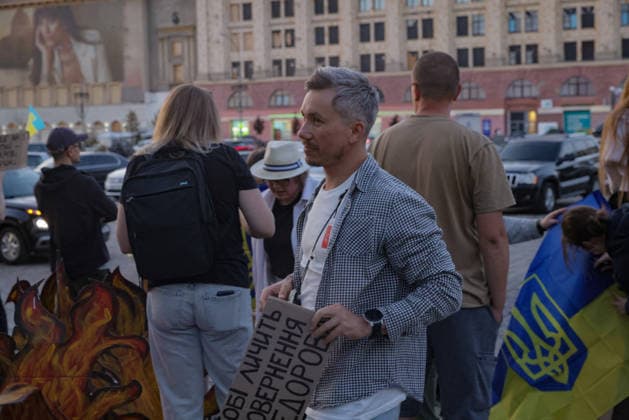 Kharkiv Protesters Demand Reinstatement of Defence Minister Fedorov - Ukraine A man holds a cardboard sign reading in Ukrainian osobysto povvernennia ( the return in person ) at a protest rally on Freedom Square (Ploshcha Svobody) in Kharkiv, Ukraine, on August 14, 2026. Demonstrators gathered to demand the reinstatement of Mykhailo Fedorov as Minister of Defence, with a Ukrainian flag bearing the trident visible at right and a flame-painted placard at left; approximately 500 Kharkiv residents joined the action that evening, part of nationwide protests ongoing since July 24. Photo by Yevhen Titov ABACAPRESS.COM Kharkiv Kharkiv Oblast Ukraine  Copyright: xTitovxYevhen ABACAx