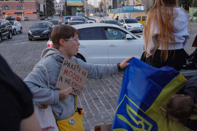 Kharkiv Protesters Demand Reinstatement of Defence Minister Fedorov - Ukraine A protester holds a cardboard sign reading ?????? ?? ??????, ? ?? ???????? ???? — Missiles to Moscow, not corruption in the rear — while reaching toward a Ukrainian national flag at Freedom Square (????? ???????) in Kharkiv, Ukraine, on August 14, 2026. The rally was part of ongoing nationwide demonstrations demanding the reinstatement of Mykhailo Fedorov as Minister of Defence, with approximately 500 Kharkiv residents joining the action that evening, organizers said. Photo by Yevhen Titov ABACAPRESS.COM Kharkiv Kharkiv Oblast Ukraine  Copyright: xTitovxYevhen ABACAx