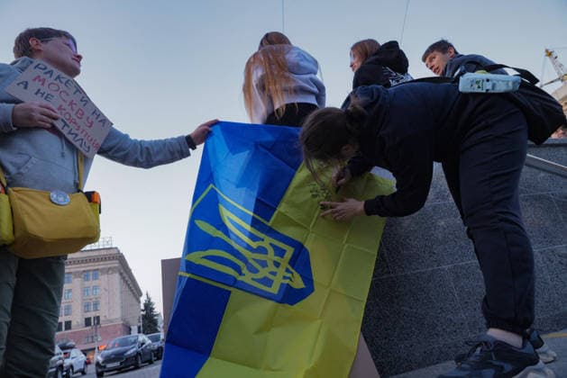 Kharkiv Protesters Demand Reinstatement of Defence Minister Fedorov - Ukraine Young demonstrators hold and sign a Ukrainian national flag bearing the trident coat of arms at a protest rally on Freedom Square (????? ???????) in Kharkiv, Ukraine, on August 14, 2026. A participant at left holds a cardboard sign reading in Ukrainian ?????? ?? ??????, ? ?? ???????? ???? ( Missiles to moscow, not rear corruption ); the rally was part of ongoing demonstrations demanding the reinstatement of Mykhailo Fedorov as Minister of Defence. Photo by Yevhen Titov ABACAPRESS.COM Kharkiv Kharkiv Oblast Ukraine  Copyright: xTitovxYevhen ABACAx