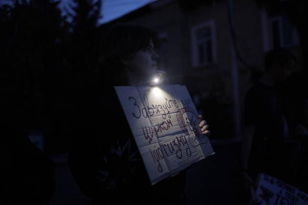 Kharkiv Protesters Demand Reinstatement of Defence Minister Fedorov - Ukraine A protester illuminates a hand-lettered cardboard sign reading ?? ??????? ? ?????? ????????? ( Contact the circus of idiocy ) with a headlamp torch during a rally at Freedom Square in Kharkiv, Ukraine, on August 14, 2026. Participants gathered to demand the reinstatement of Mykhailo Fedorov as Minister of Defence, part of ongoing nationwide demonstrations against President Zelensky s dismissal of Fedorov. Photo by Yevhen Titov ABACAPRESS.COM Kharkiv Kharkiv Oblast Ukraine  Copyright: xTitovxYevhen ABACAx