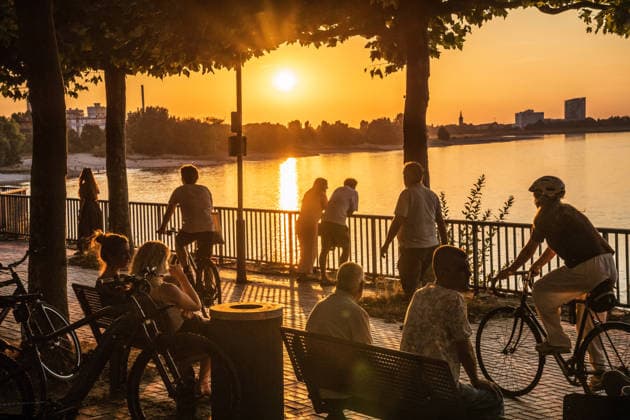 Menschen genießen den warmen Sommerabend am Rheinufer, Düsseldorf, 14. August 2026 Deutschland, Düsseldorf, 14. August 2026, Menschen genießen den Sonnenuntergang am Rheinufer, sitzen unter Bäumen, gehen spazieren oder fahren Rad, ein heißer Sommertag geht zu Ende, goldenes Abendlicht, Parlamentsufer in der Nähe des Landtags, abends um 20:25 Uhr, schönes Wetter, Hochsommer, Hitzewelle, Sommer, Wetter, Nordrhein-Westfalen, NRW, *** People are enjoying the warm summer evening on the banks of the Rhine, Düsseldorf, August 14, 2026, Germany, Düsseldorf, August 14, 2026, People are enjoying the sunset along the banks of the Rhine, sitting under trees, going for walks, or riding bikes; a hot summer day is coming to an end; golden evening