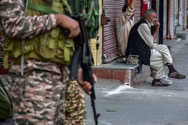 India celebrates Independence day amid heightened security - 15 Aug 2026 Kashmiri men rest at the closed market as an Indian paramilitary trooper stands alert during the India s 80th Independence celebrations in Srinagar. The administration celebrated Independence day across the Kashmir valley amid heightened security arrangements. Srinagar India Copyright: xSaqibxMajeedx xSOPAxImagesx M_SAQIB_150826 (3)