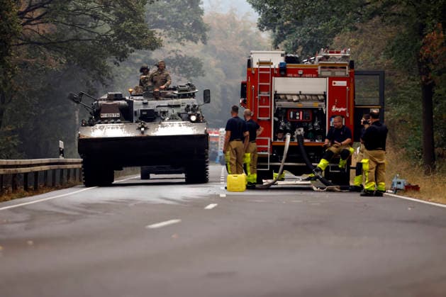 News Bilder des Tages Hubschrauber von Bundeswehr und Bundespolizei, Bergepanzer der Bundeswehr und zahlreiche Kräfte von Feuerwehr und anderen Freiwilligen sind beim Waldbrand im Hürtgenwald im Einsatz. Mehrere Hundert Hektar Waldfläche stehen in Flammen, die Feuerwalze hat sich bis dicht an einzelne Stadtteile herangefressen. Bauern und Helfer bringen immer wieder neue Wassertanks heran. Wegen der anhaltenden Hitzewelle sind die Wälter extrem trocken. Hürtgenwald, 15.08.2026 NRW Deutschland *** Helicopters from the German Armed Forces and the Federal Police, armored recovery vehicles from the German Armed Forces, and numerous firefighters and other volunteers are on the scene of the wildfire in the Hürtgenwald. Several hundred hectares of forest are ablaz Copyright: xChristophxHardtx