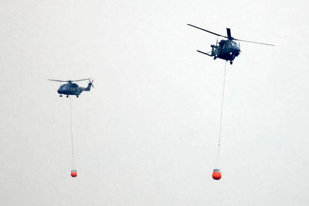 Hubschrauber von Bundeswehr und Bundespolizei, Bergepanzer der Bundeswehr und zahlreiche Kräfte von Feuerwehr und anderen Freiwilligen sind beim Waldbrand im Hürtgenwald im Einsatz. Mehrere Hundert Hektar Waldfläche stehen in Flammen, die Feuerwalze hat sich bis dicht an einzelne Stadtteile herangefressen. Bauern und Helfer bringen immer wieder neue Wassertanks heran. Wegen der anhaltenden Hitzewelle sind die Wälter extrem trocken. Hürtgenwald, 15.08.2026 NRW Deutschland *** Helicopters from the German Armed Forces and the Federal Police, armored recovery vehicles from the German Armed Forces, and numerous firefighters and other volunteers are on the scene of the wildfire in the Hürtgenwald. Several hundred hectares of forest are ablaz Copyright: xChristophxHardtx